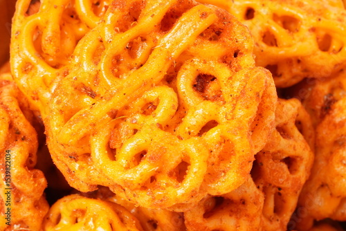 A pile of spicy Indonesian crackers or Kerupuk with spiral twists, coated in red-orange chili powder and rich spices. Bold, flavorful, and appetite-boosting. Photographed against a white background.