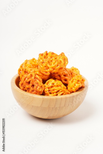 A pile of spicy Indonesian crackers or Kerupuk with spiral twists, coated in red-orange chili powder and rich spices. Bold, flavorful, and appetite-boosting. Photographed against a white background.