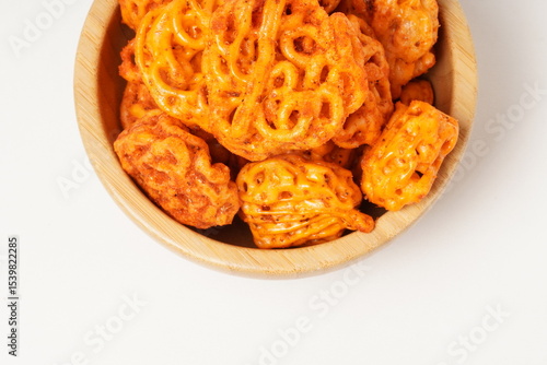 A pile of spicy Indonesian crackers or Kerupuk with spiral twists, coated in red-orange chili powder and rich spices. Bold, flavorful, and appetite-boosting. Photographed against a white background.
