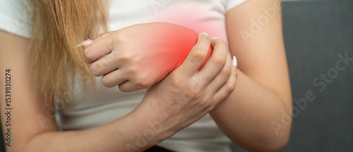 Wallpaper Mural Wrist Pain Awareness. Young woman holding her wrist in discomfort. Torontodigital.ca