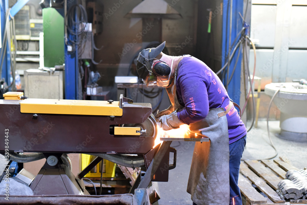 Welder in protective clothing at the workplace in an industrial company in steel construction Welder in protective clothing at the workplace in an industrial company in steel construction