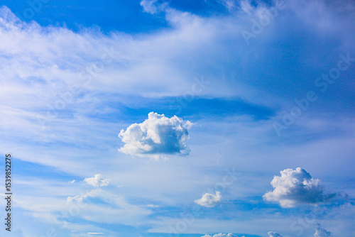 The evening sky is filled with thick and thin clouds against a backdrop of pale blue and lavender. Natural light adds depth and dimension to the clouds, creating a peaceful and beautiful atmosphere.