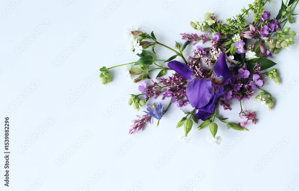 Fototapeta premium A summer bouquet with an iris in lilac tones. A flower arrangement with a place for text.