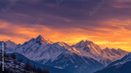 Breathtaking panoramic view of snow capped mountain range at sunset du winter