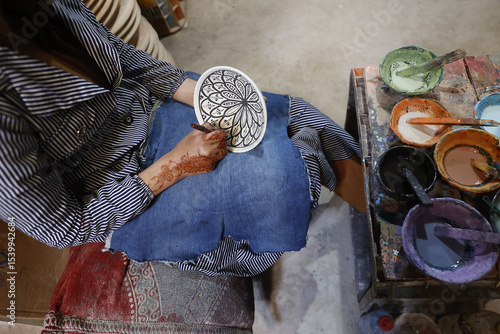 Worker painting bowls in a pottery workshop, Safi, Morocco
