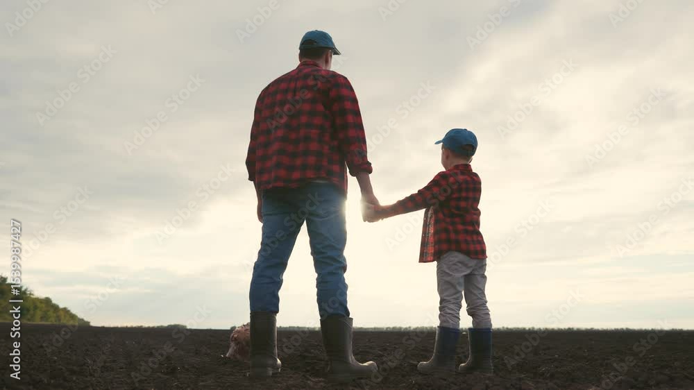 Father and son in a field. Silhouette of farmers and their son lifestyle plowing a field. Family holding their father sons hand. A dad and his son in a meadow. Father and son in a field. Silhouette of farmers and their son lifestyle plowing a field. Family holding their father sons hand. A dad and his son in a meadow.