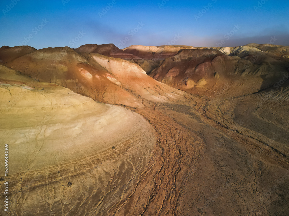 Fototapeta premium Aerial view tracing deep ravines and dramatic Aktumsuk landforms in Uzbekistan