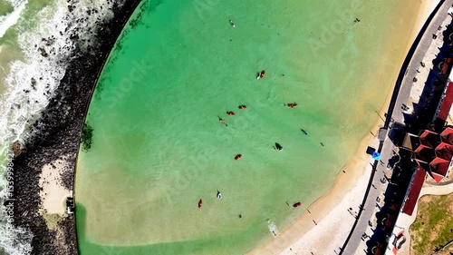Drone pull out clip of a tidal pool in Cape Town South Africa with people leisurely enjoying the summer day