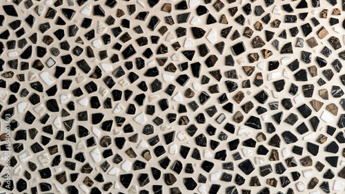 Close up of a mosaic tile pattern with black white and brown irregular shaped pieces in a random design