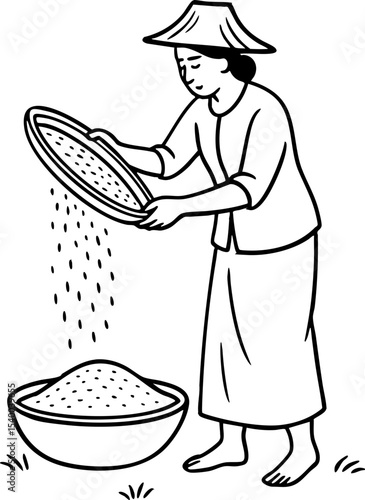 Asian farmer winnowing rice