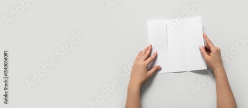 Hands holding blank brochur...