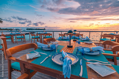 Fotografie Outstanding overwater restaurant with dinner tables set for romantic luxury dini