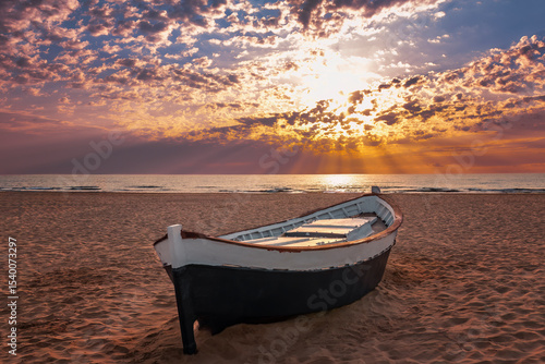barca varada en la arena de la playa de la Malvarrosa, Valencia, España, al amanecer