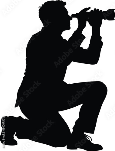 Silhouette of a kneeling man with a professional camera, taking photographs