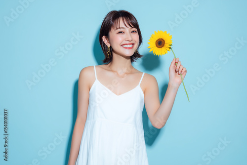 ひまわりを持つ笑顔の女性