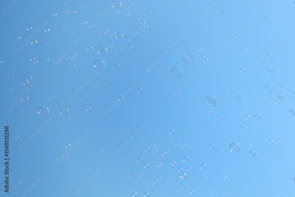 Beautiful soap bubbles floating on blue sky background Beautiful soap bubbles floating on blue sky background