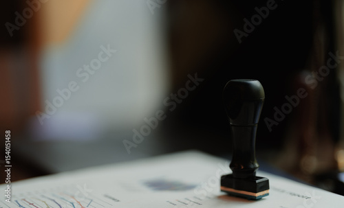 Close-up of a summary report stamped 'APPROVED' with a black rubber stamp on an office desk. Pen, document folder, and natural light complete the scene.
