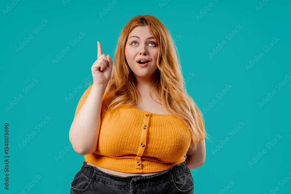 Plus size woman model surprised, wow idea effect, eureka reaction. Lady with excited expression pointing to up Plus size woman model surprised, wow idea effect, eureka reaction. Lady with excited expression pointing to up