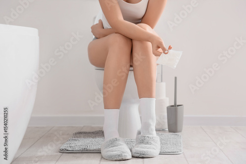Canvas Print Young woman on period in restroom