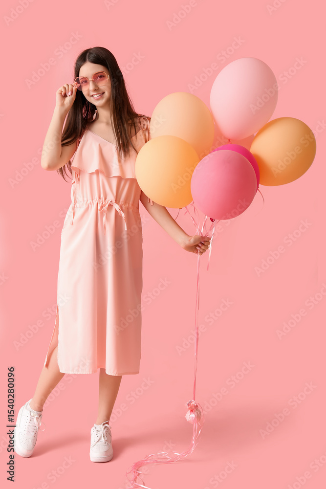 Beautiful teenage girl in sunglasses with colorful air balloons on pink background Beautiful teenage girl in sunglasses with colorful air balloons on pink background