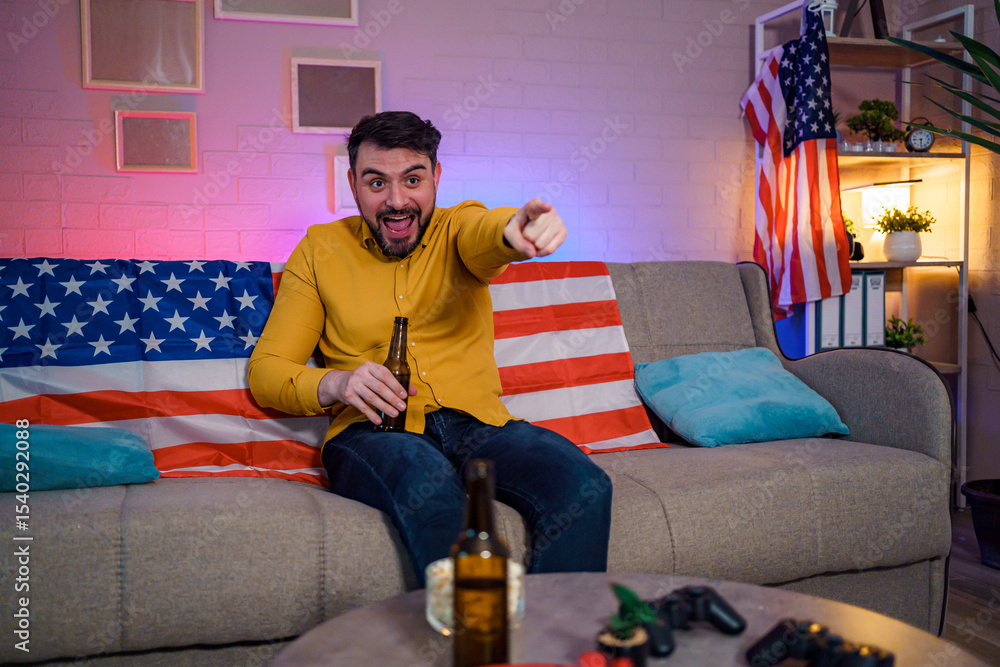 Obraz premium Man enjoying a lively moment on a couch with an American flag