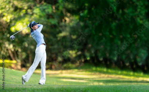 A woman is swinging a golf club