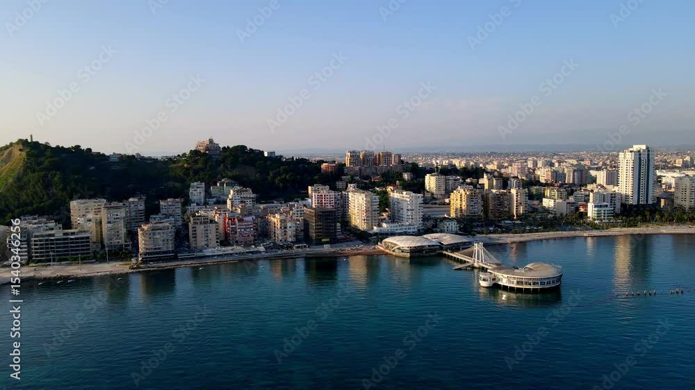 Scenic aerial drone video showing a view from the Adriatic Sea toward the coastline of Durrës, Albania. The footage captures the beachfront, urban skyline, and coastal architecture Scenic aerial drone video showing a view from the Adriatic Sea toward the coastline of Durrës, Albania. The footage captures the beachfront, urban skyline, and coastal architecture