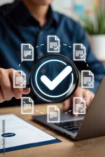 Magnifying glass highlighting approved documents on a laptop.