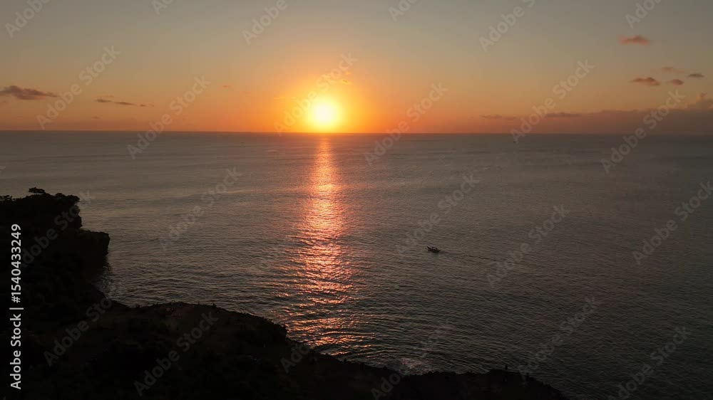 Aerial view of sunset or sunrise on the ocean with calm wave in Bali. Dusk or dawn on the beach with clear sky. Sunlight reflection on middle of the sea. Wide angle cinematic for opening ending scene. Aerial view of sunset or sunrise on the ocean with calm wave in Bali. Dusk or dawn on the beach with clear sky. Sunlight reflection on middle of the sea. Wide angle cinematic for opening ending scene.