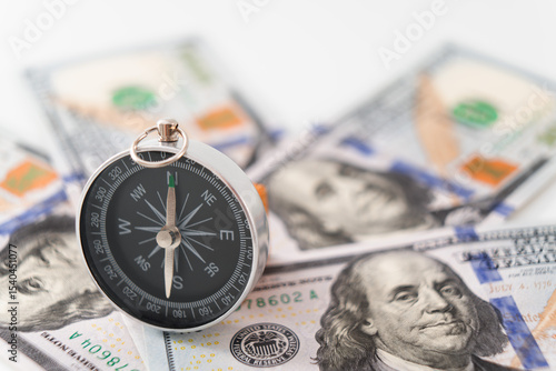 Interest rate direction concept featuring angle view of standing compass on US Dollar banknote 