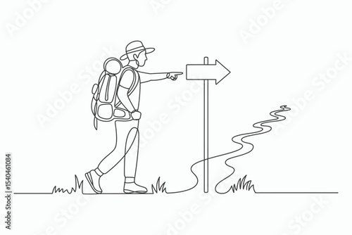 Hiker with backpack following a trail sign