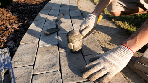 Laying paving stones on cement mortar. Laying a garden path made of tiles. Self-laying of concrete paving slabs in the courtyard of the house. do it yourself. DIY