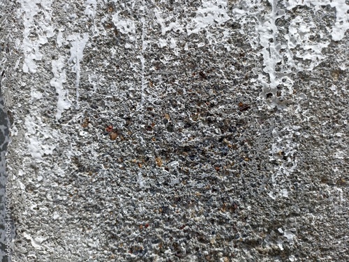 Rough Concrete Wall with Peeling White Paint Texture. Close-up of rough concrete wall with peeling white paint and gritty texture. Ideal for grunge backgrounds or urban decay themes