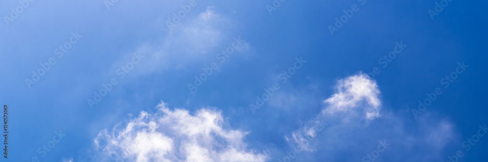 Clear blue sky with a few clouds. The sky is very bright and the clouds are scattered throughout Clear blue sky with a few clouds. The sky is very bright and the clouds are scattered throughout