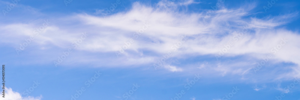 Fototapeta premium Clear blue sky with a few clouds. The sky is very bright and the clouds are scattered throughout