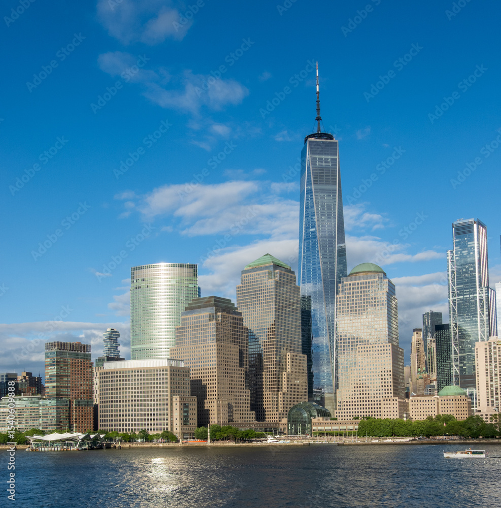 Fototapeta premium Tall office buidlings and One World Trade Center along the waterfront in Lower Manhattan as seen from Hudson River