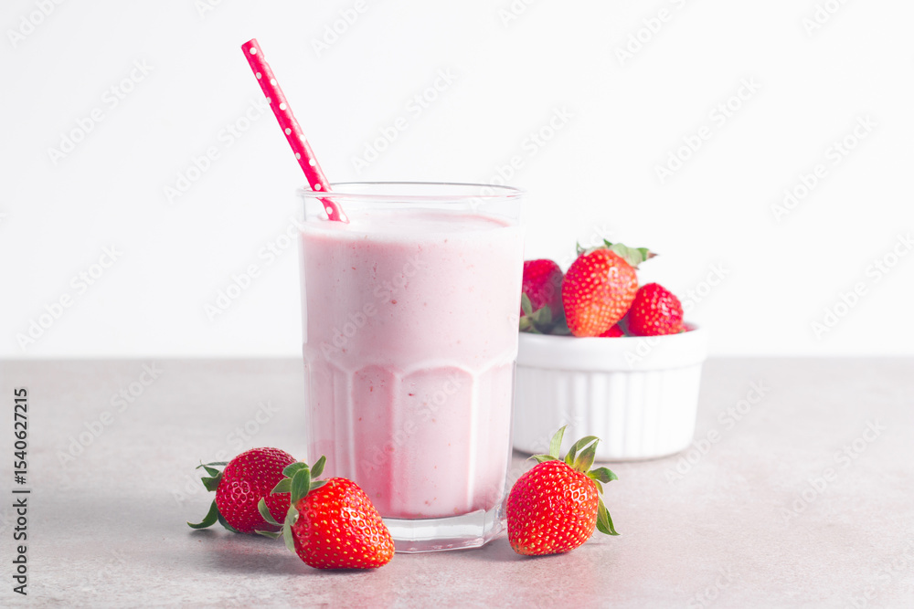 Glass of fresh strawberry milkshake, smoothie and fresh strawberries on white and wooden background. Healthy food and drink concept. Glass of fresh strawberry milkshake, smoothie and fresh strawberries on white and wooden background. Healthy food and drink concept.