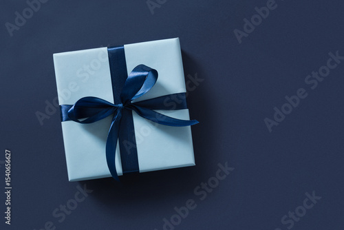 Blue gift box on navy blue background. Flat lay. Happy Fathers Day. Greeting card. View from above. Copy space.
