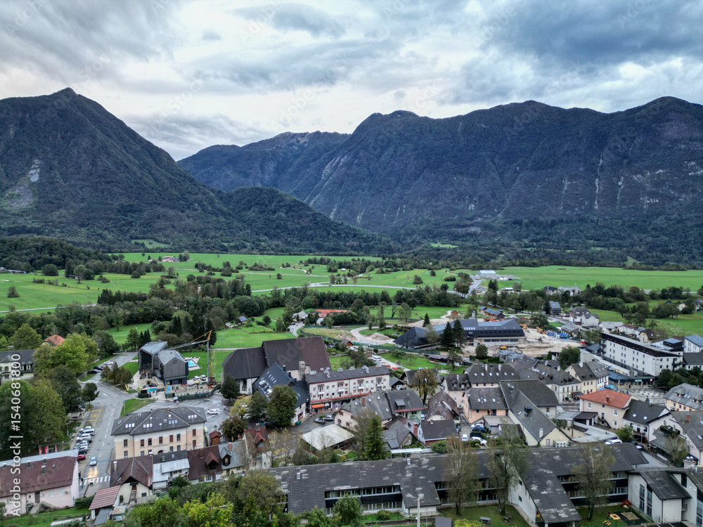 Obraz premium scenic view of bovec slovenia, small european village in the julian alps with beautiful mountains (aerial drone birds eye view looking down) mountain landscape hills outdoor adventure soca valley