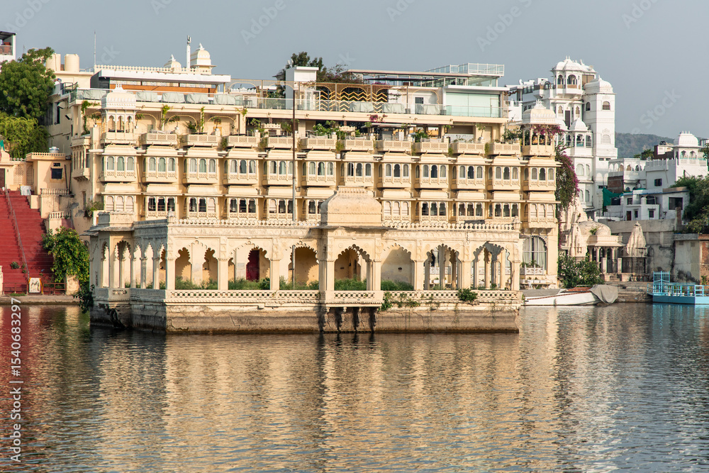 Fototapeta premium Lake Pichola reflecting the facade of the luxurious Taj Lake Palace hotel in Udaipur