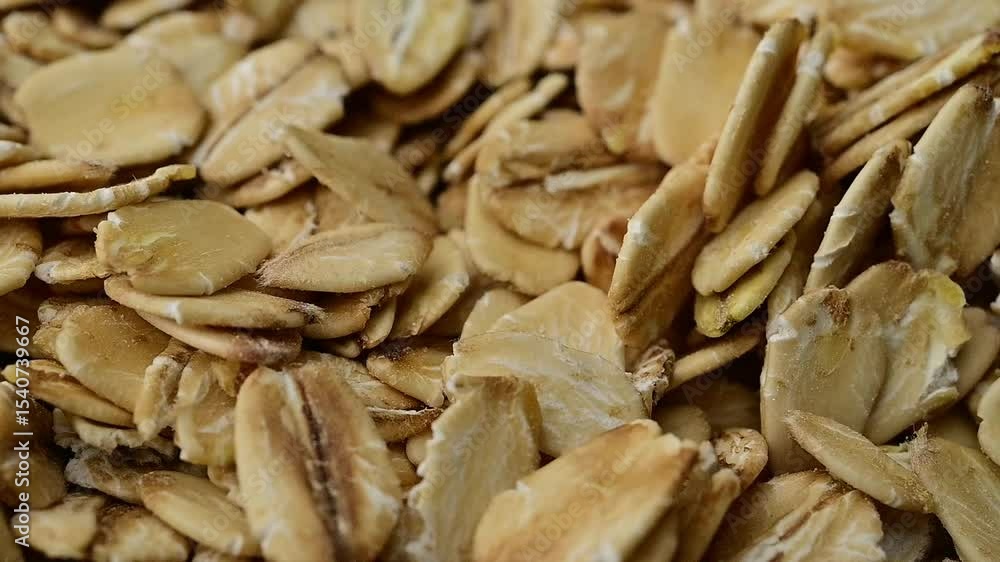 Close-Up Pan of Golden Rolled Oats: Healthy Breakfast Ingredient in Motion Close-Up Pan of Golden Rolled Oats: Healthy Breakfast Ingredient in Motion