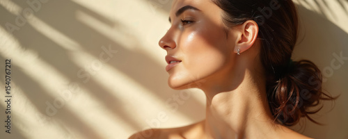 Brunette woman with clean, glowy skin in natural light. Side profile, close-up of face. Healthy complexion, beauty, wellness. Fresh, youthful lady with no makeup.