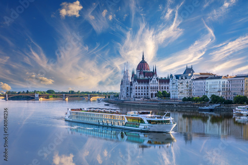 View of cruise ship on the Danube and Budapest Parliament under dramatic sky, Hungary