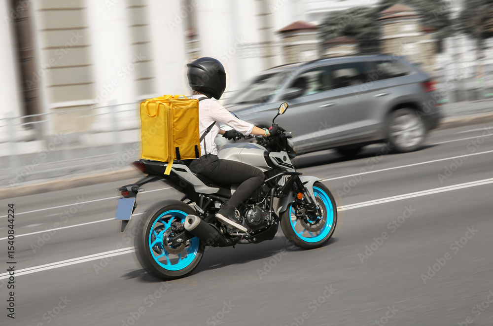 Fototapeta premium Abstract image of a courier on a motorcycle on a blurred background