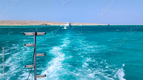 Slow motion in sea on yacht, Bright turquoise water and sparkling waves with foam on sunny day, beautiful scene from happy vacation, view from sailing ship to rich yachts of red sea, for travel video