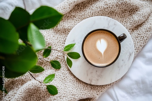 Coffee With Heart-Shaped Latte Art on a Marble Coaster Beside Green Leaves