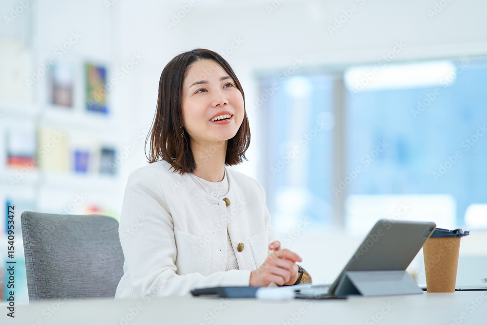 仕事中に同僚と会話する女性 仕事中に同僚と会話する女性