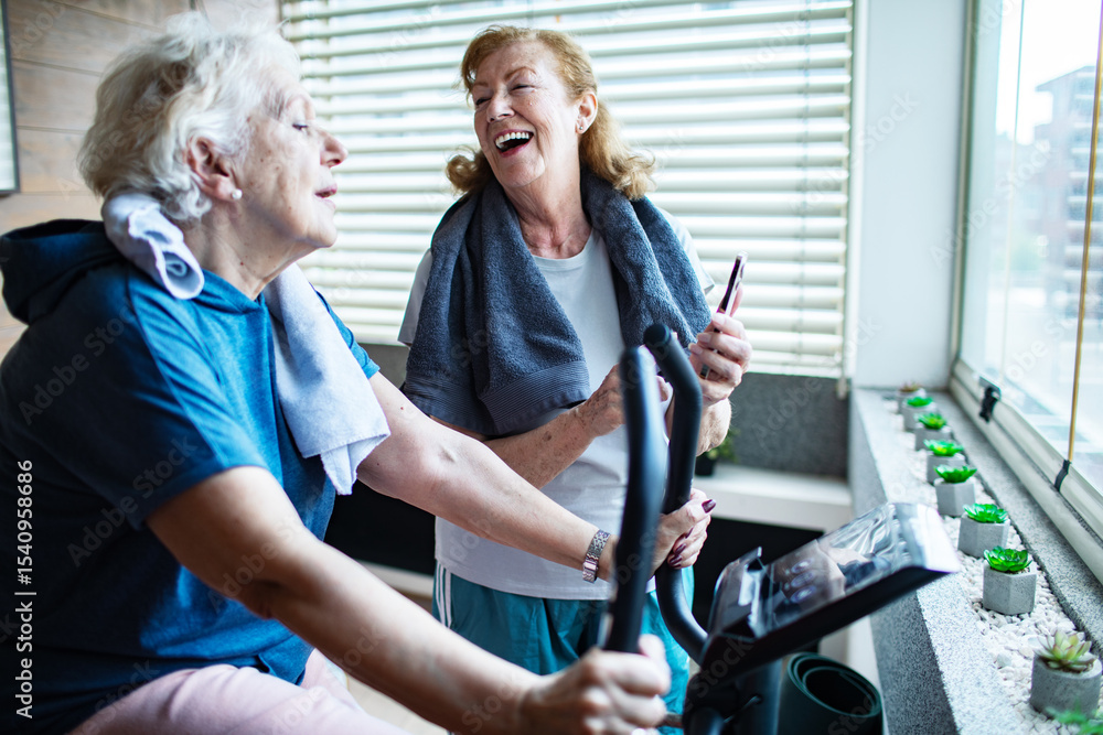 Obraz premium Senior lesbian couple exercising together at home and cheering each other on