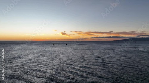Waikiki orange sunset with sailboats and waves