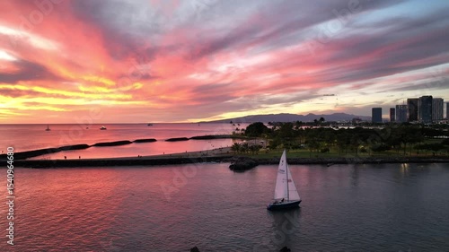 White sail by Magic Island in Ala Moana with Pink Sky Sunset